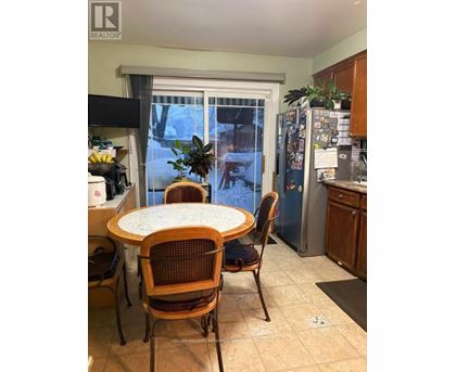 A kitchen with a table and chairs in front of a window.