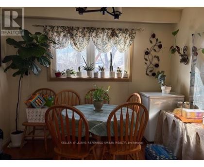 A dining room with a table and chairs.