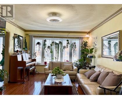A living room with a brown couch and a piano.