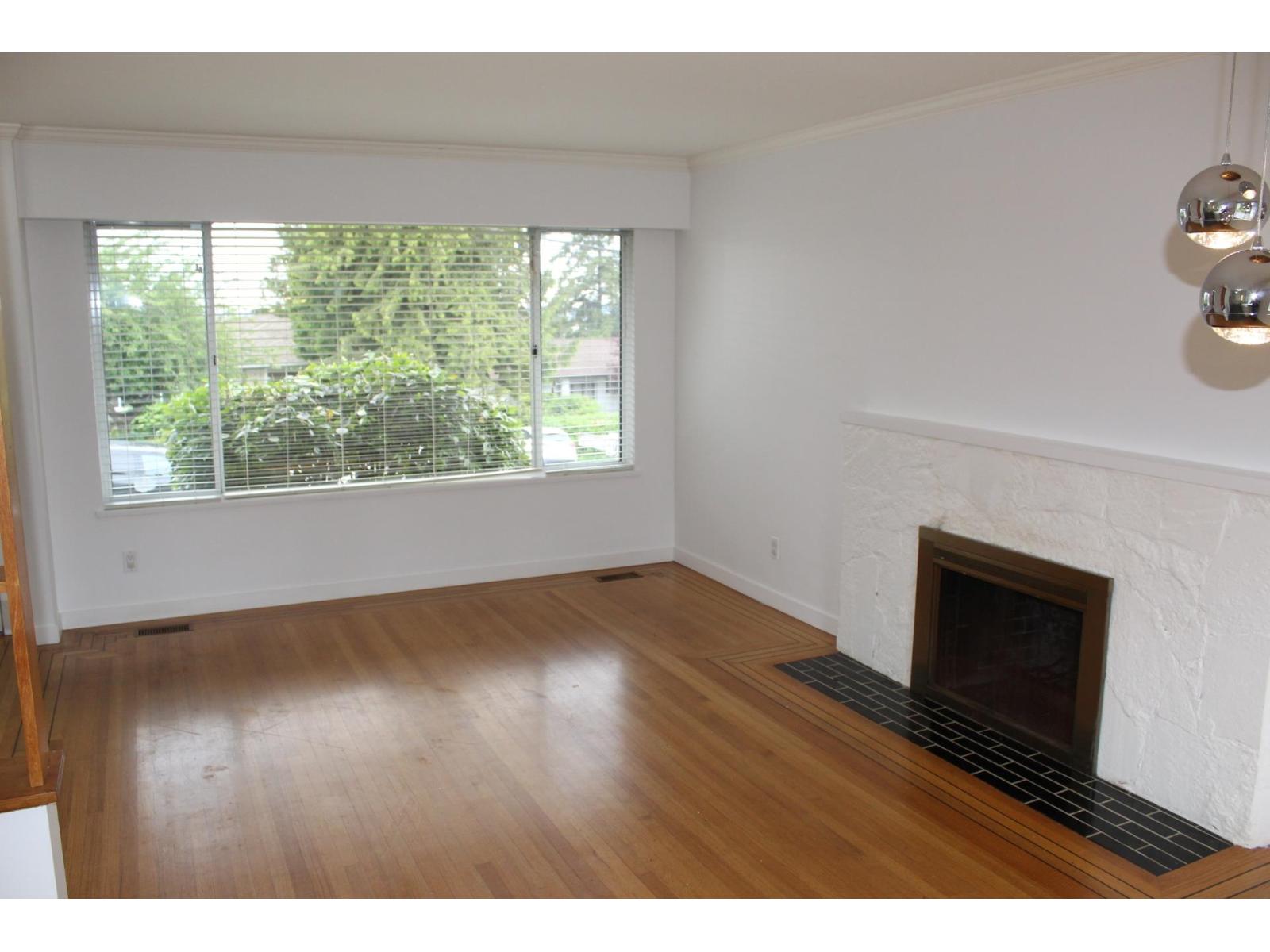 A room with a fireplace and a window with blinds.