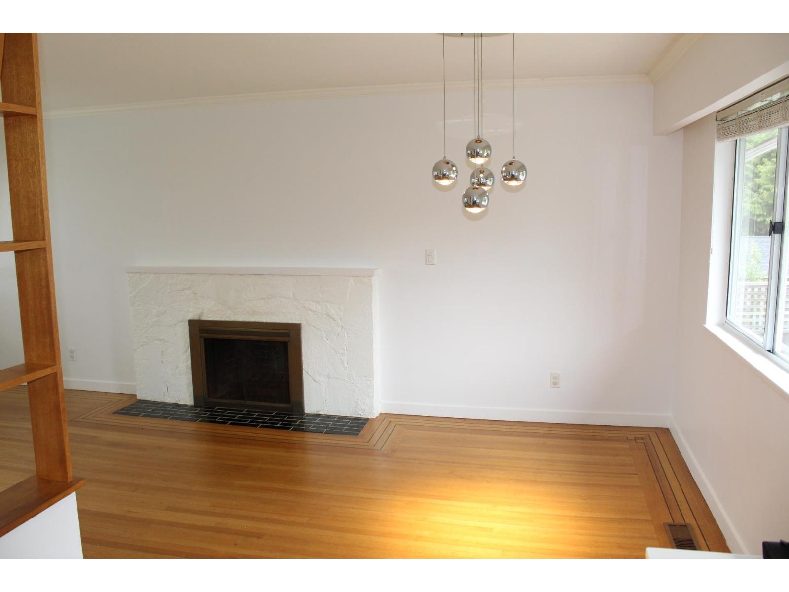 A living room with a fireplace and a wooden floor.