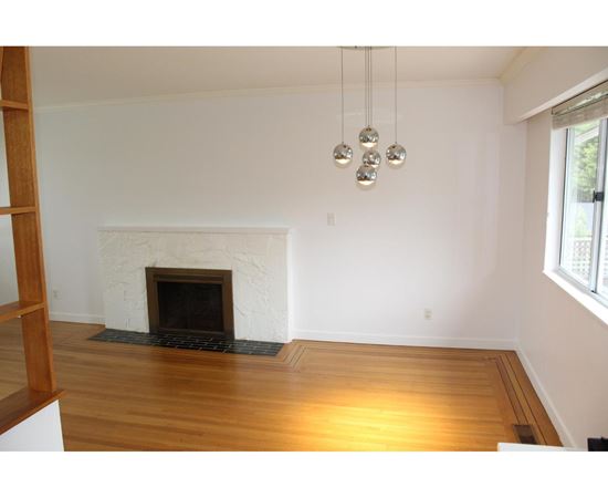 A living room with a fireplace and a wooden floor.
