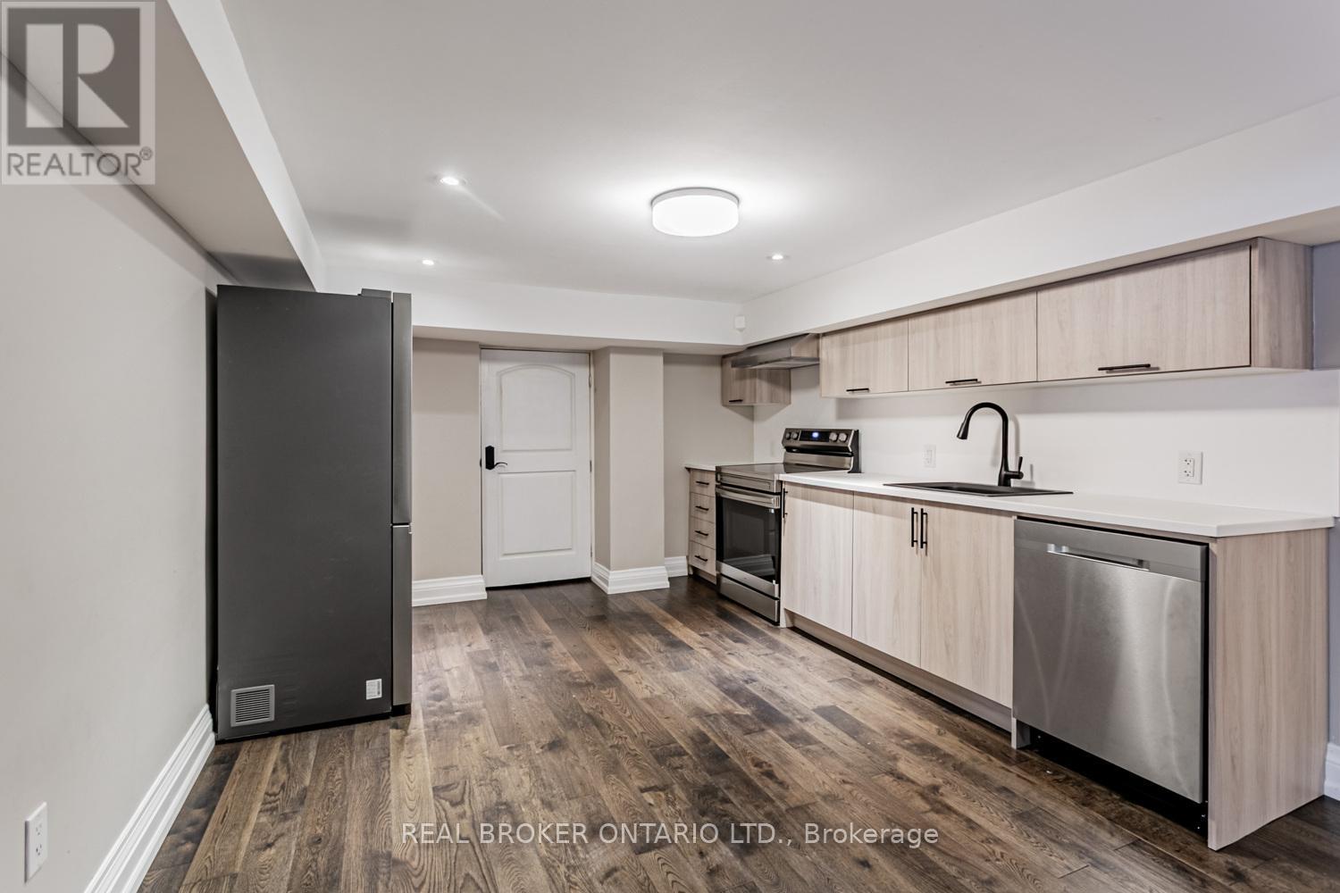 A kitchen with a black fridge and stainless steel dishwasher.
