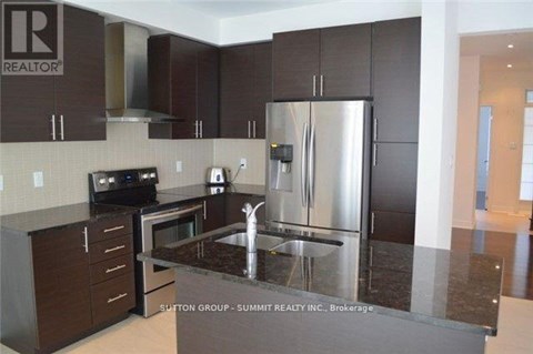 A modern kitchen with dark brown cabinets and stainless steel appliances.