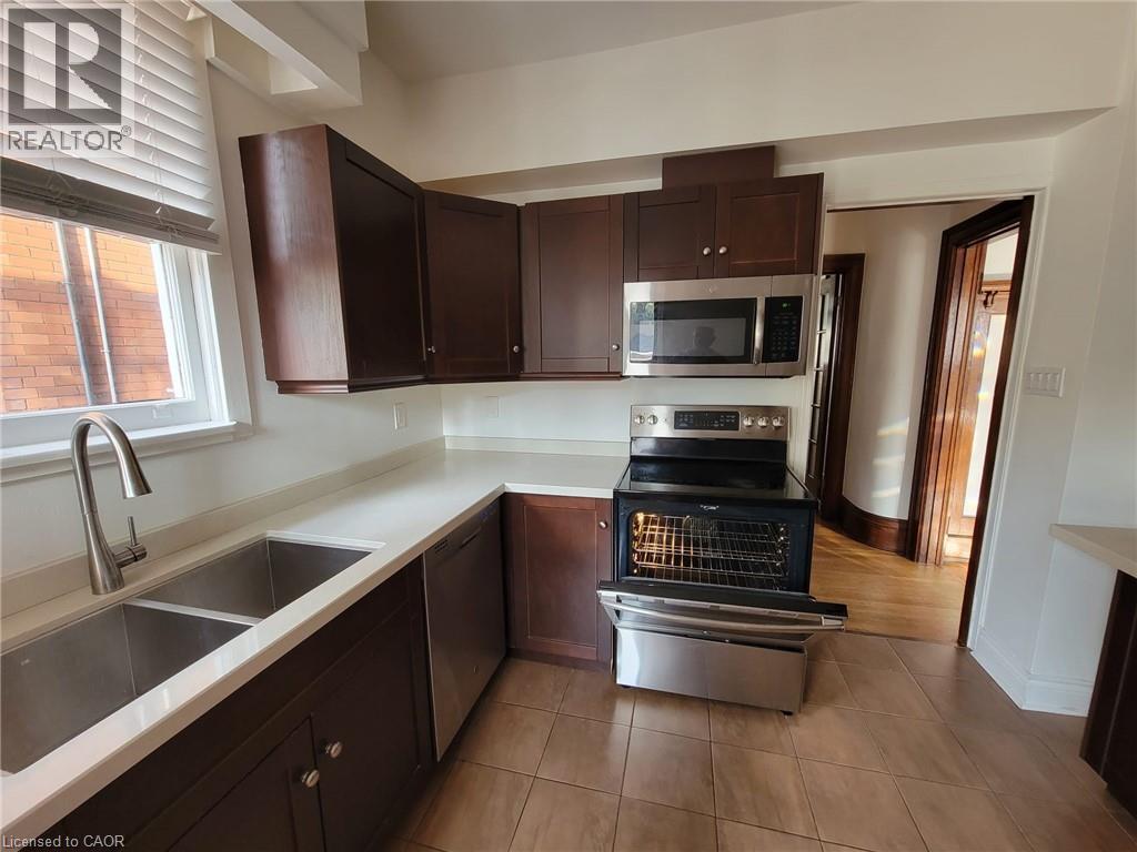 A kitchen with brown cabinets and a stainless steel oven.