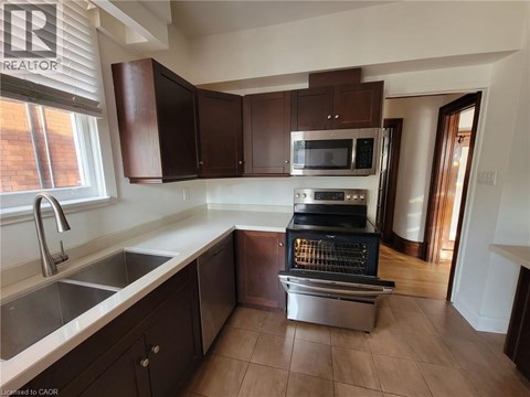 A kitchen with brown cabinets and a stainless steel oven.