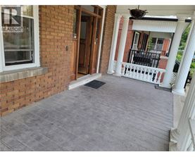 A porch with a grey floor and a white railing.