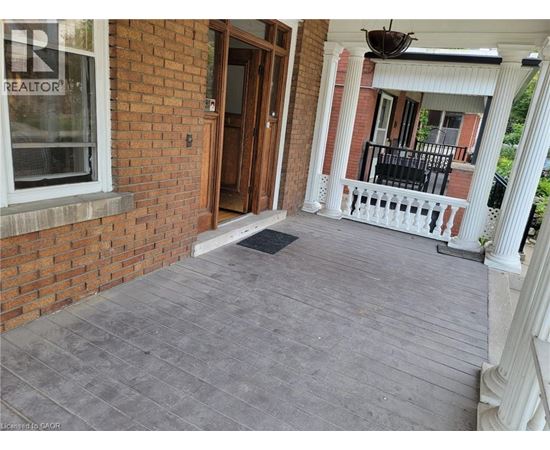 A porch with a grey floor and a white railing.