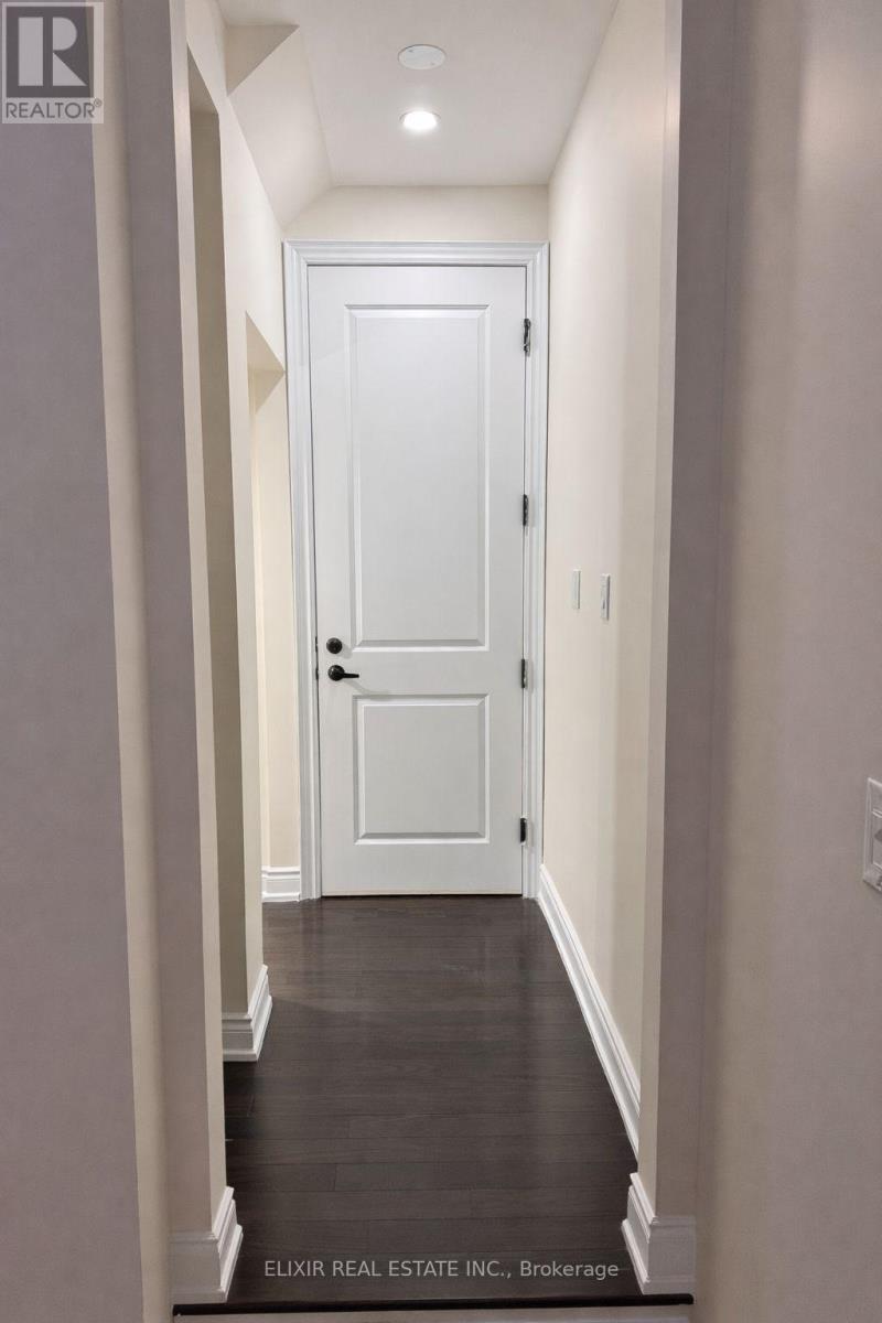 A hallway with a white door and a sign that says Elixir Real Estate Inc. Brokerage.