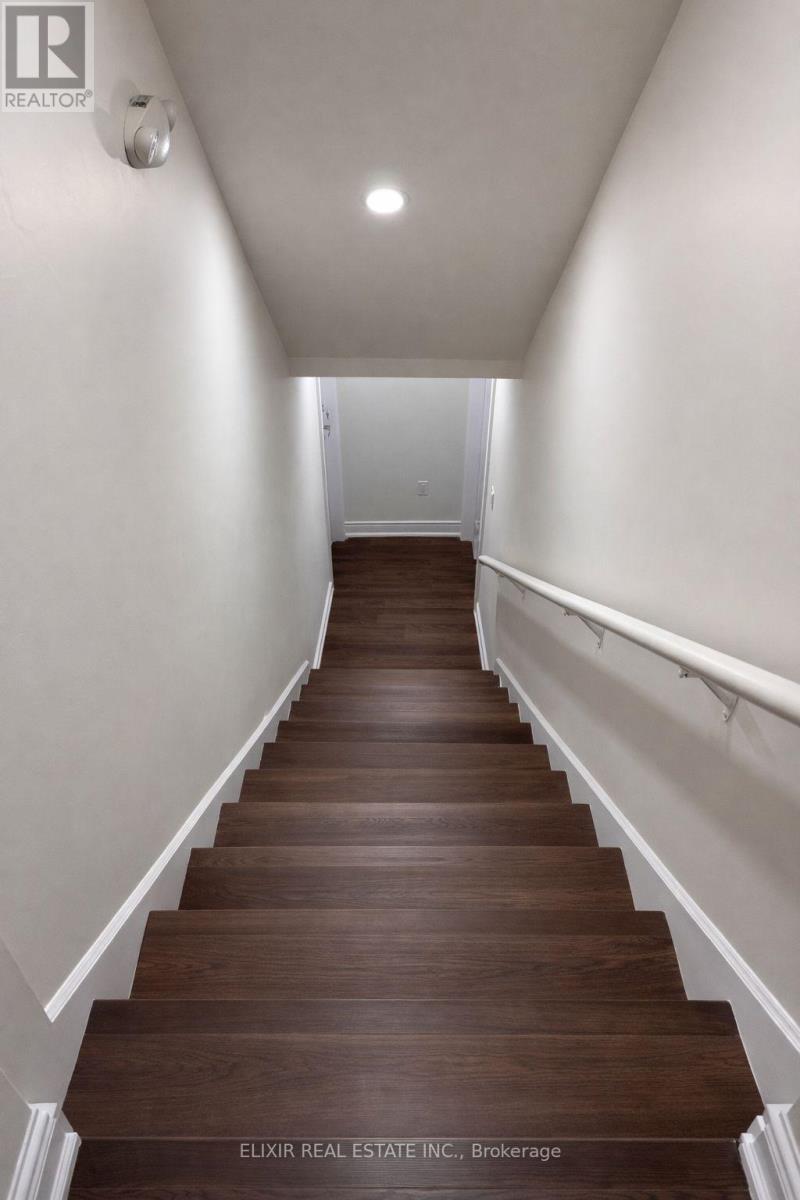 A long flight of stairs with white walls on either side.
