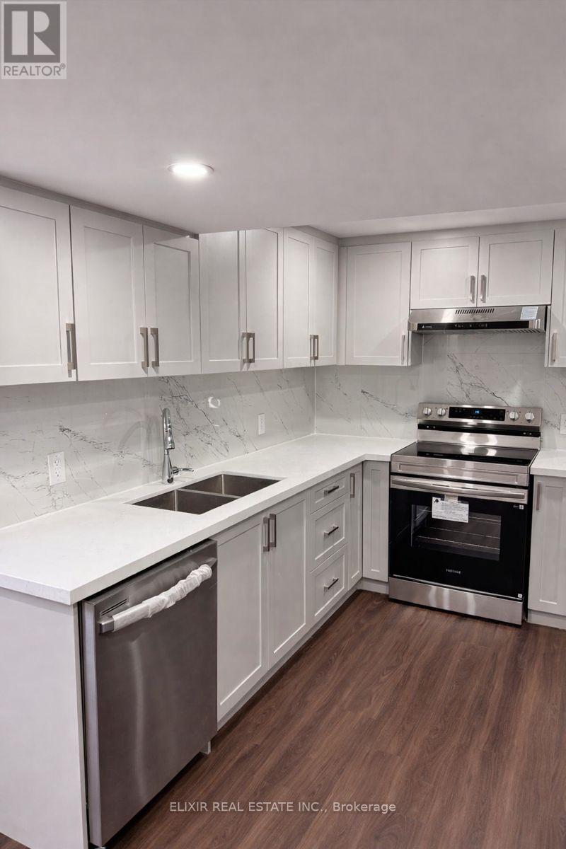 A modern kitchen with white cabinets and stainless steel appliances.