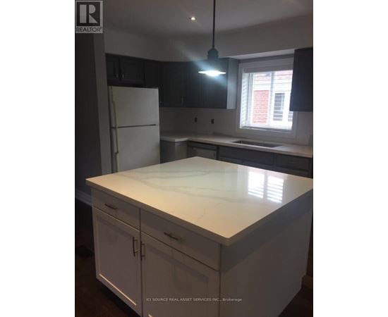 A kitchen with a white counter top and cabinets.