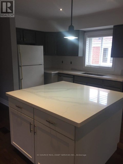 A kitchen with a white counter top and cabinets.