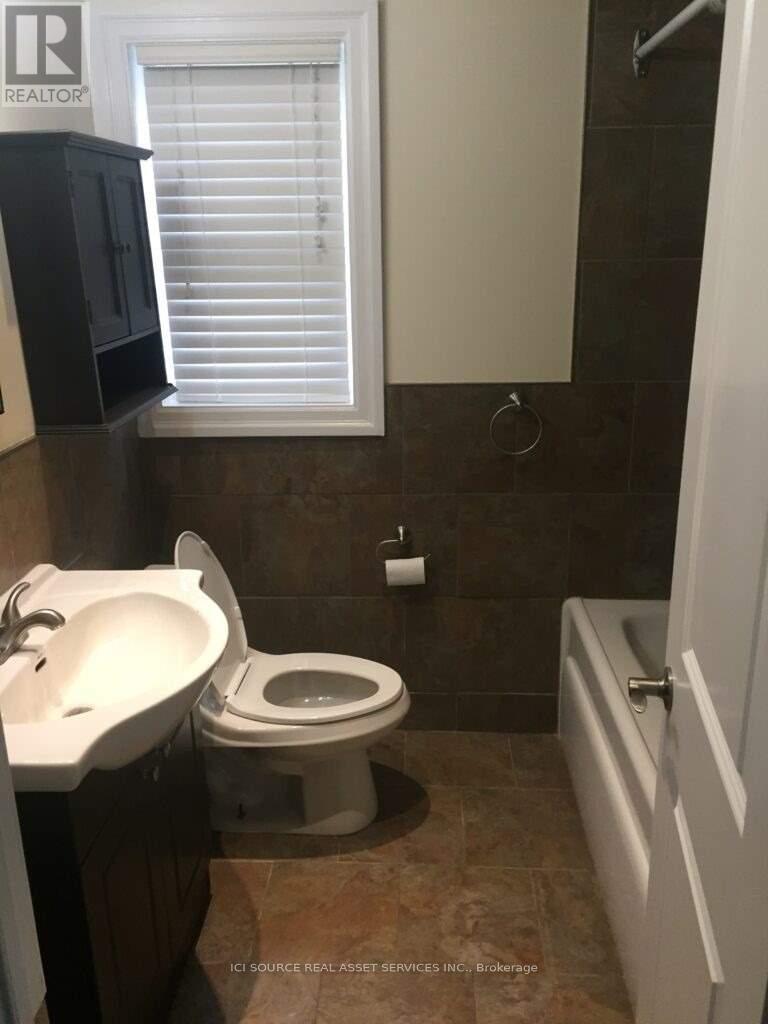 A bathroom with a toilet, sink, and shower.