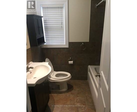 A bathroom with a toilet, sink, and shower.