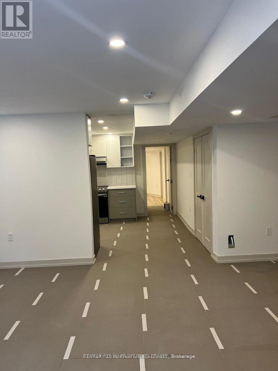 A spacious room with wooden flooring and white walls.