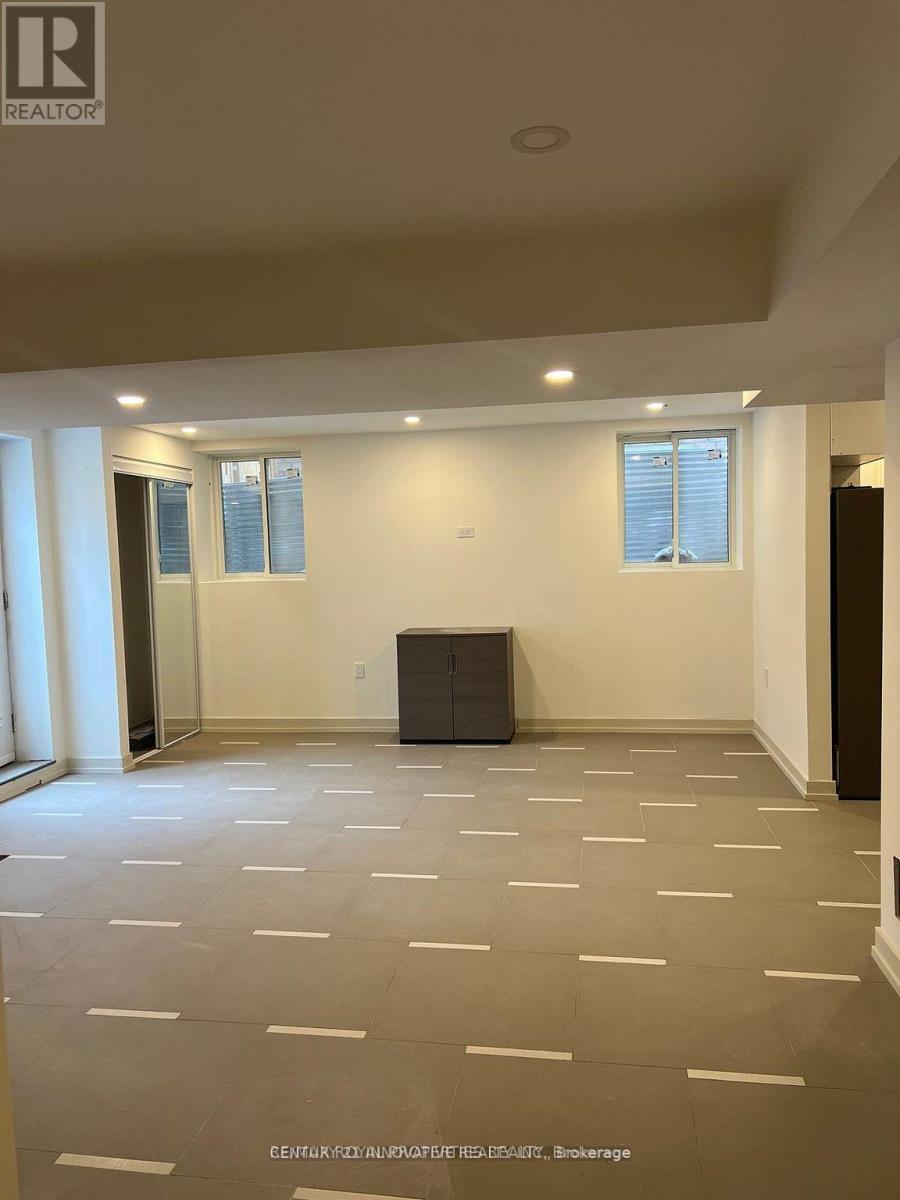 A spacious room with a staircase and wooden flooring.