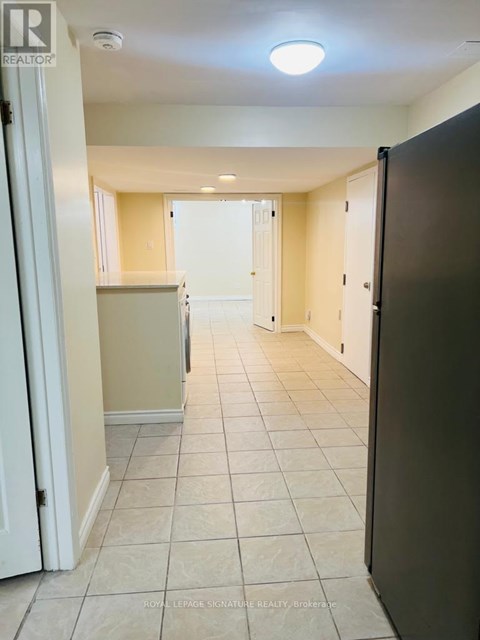 A kitchen area with a black refrigerator and white cabinets.