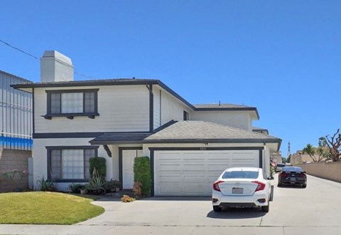 A white car is parked in front of a garage.