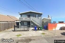 A two-story house with a garage and a fence in front.