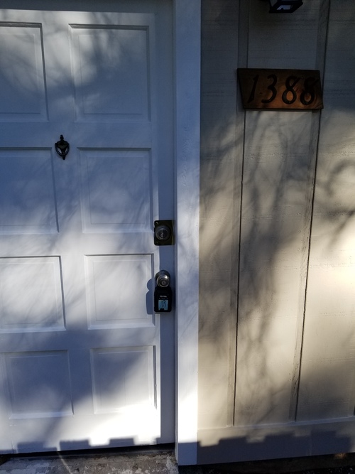 A white door with a black handle and a mailbox with the number 1388 on it.