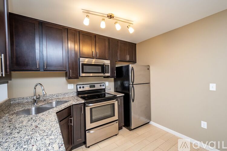 A kitchen with a granite countertop and stainless steel appliances.