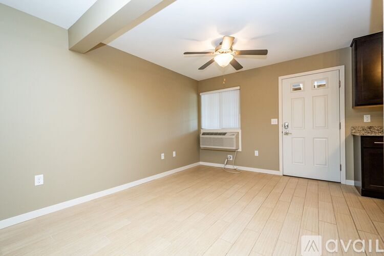 A room with a ceiling fan and a door.