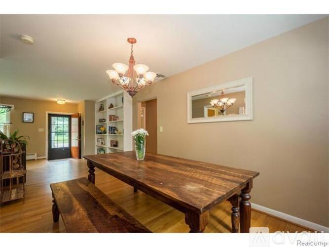 A wooden table with a vase of flowers on it in a room.