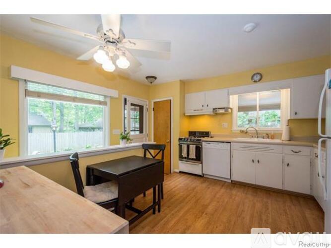 A kitchen with a table and chairs in front of a window.