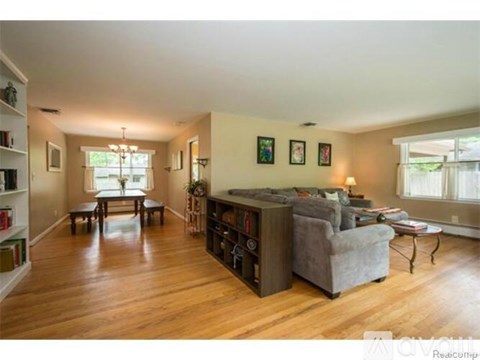 A living room with a grey couch and a wooden floor.