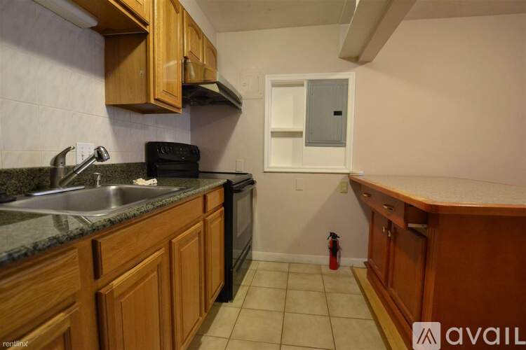 A kitchen with wooden cabinets and a black stove top oven.