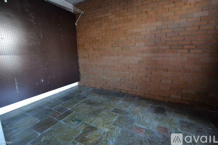 A room with a brick wall and stone floor.