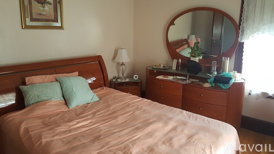 A bedroom with a bed, nightstand, and a mirror.