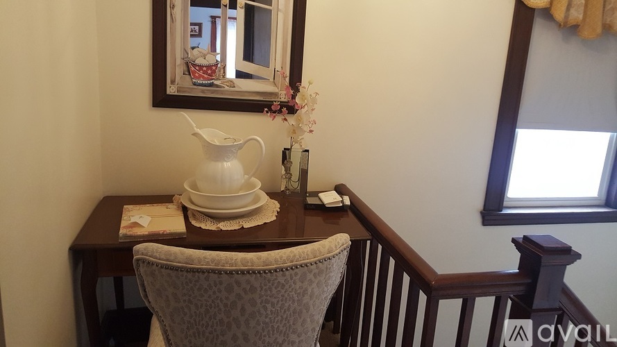 A table with a white pitcher and a plate on it.