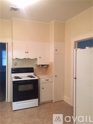 A kitchen with white cabinets and a black stove top oven.