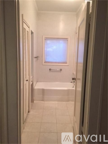 A bathroom with a tub and a window.