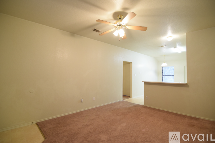 A room with a carpeted floor and a ceiling fan.
