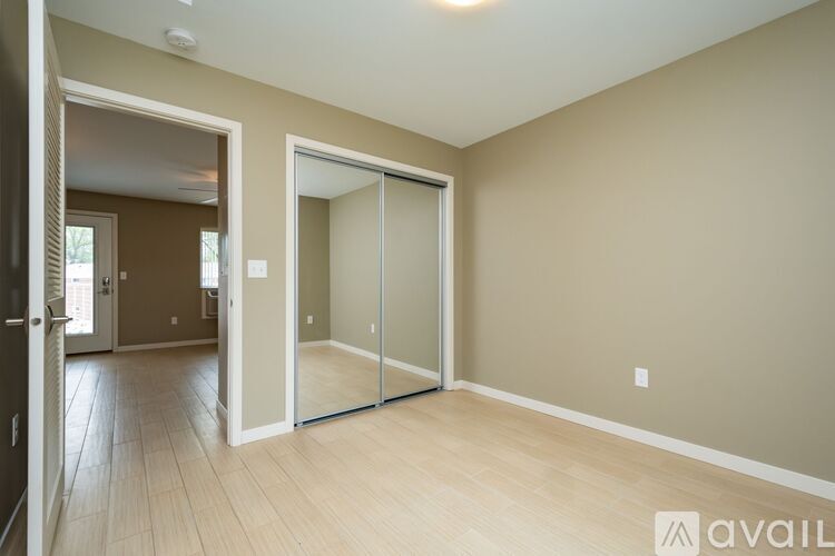A spacious room with a sliding glass door and wooden flooring.