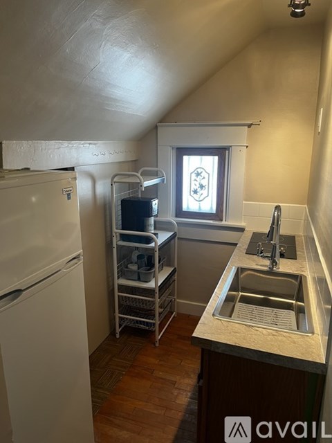 A kitchen with a white refrigerator, a sink, and a window.