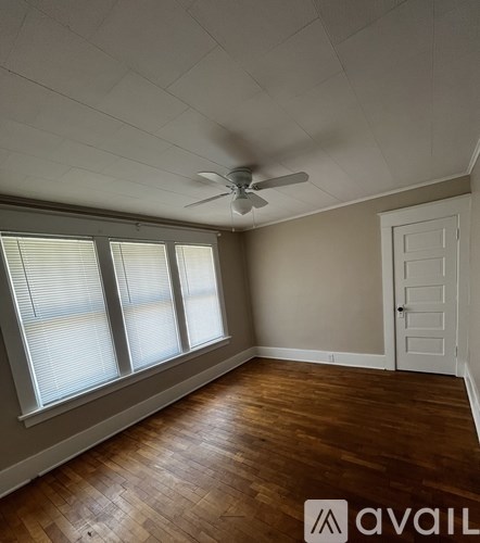 A room with a ceiling fan and wooden flooring.