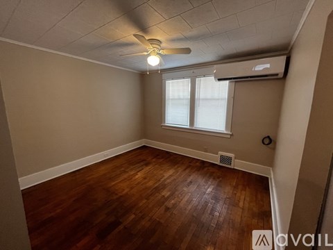 A room with wooden flooring and a ceiling fan.