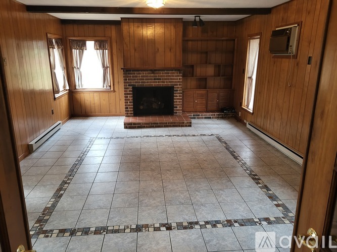 A living room with a fireplace and tiled floor.