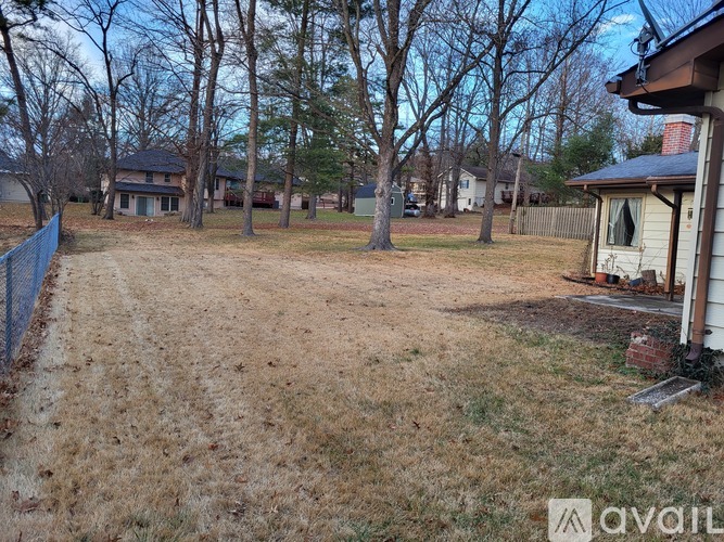 A backyard with a fence and trees.