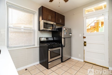 A kitchen with a black stove top oven and a black microwave above it.