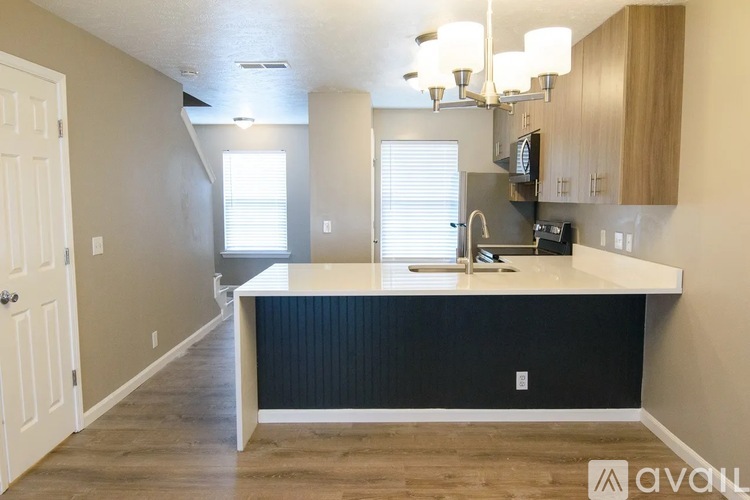 A kitchen with a white countertop and wooden cabinets.