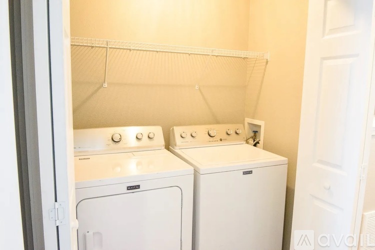Two white front loading washing machines in a small laundry room.