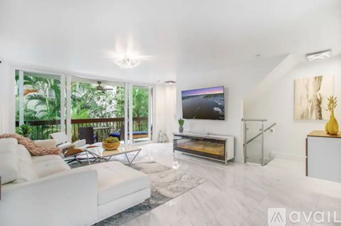 A modern living room with a white sofa and a television.