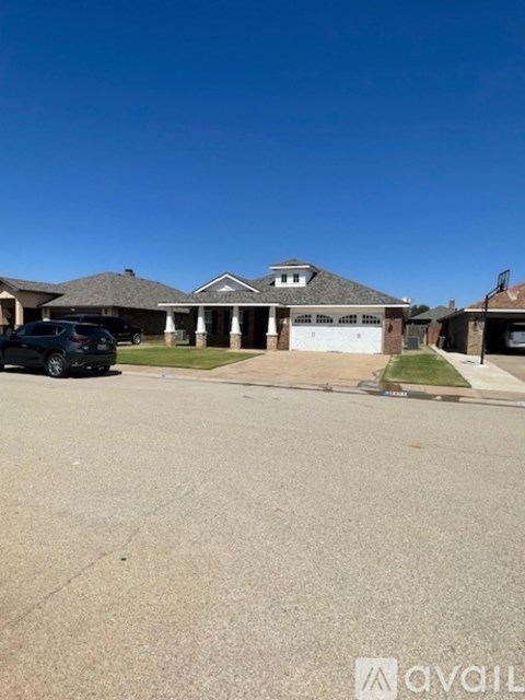 A car is parked in front of a house with a garage.