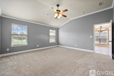 A spacious room with a ceiling fan and carpeted floor.