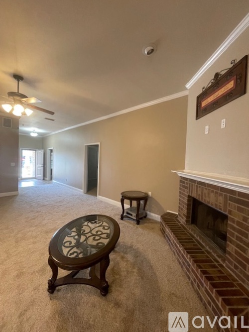 A living room with a fireplace and a ceiling fan.